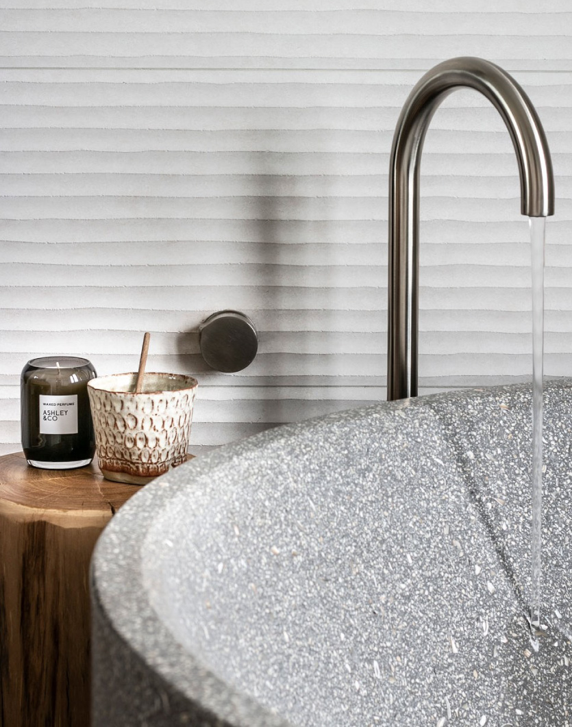 a close up of a freestanding bath in a textured finish